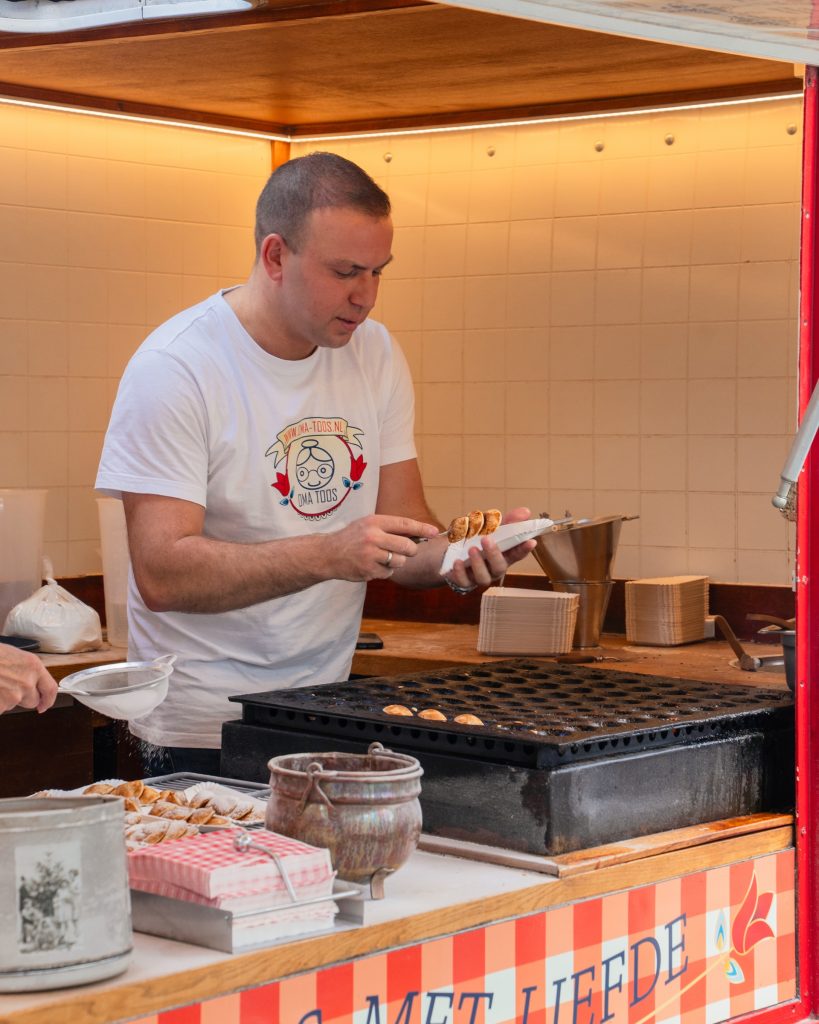 Bakker aan het werk bij de poffertjeskraam van Oma Toos